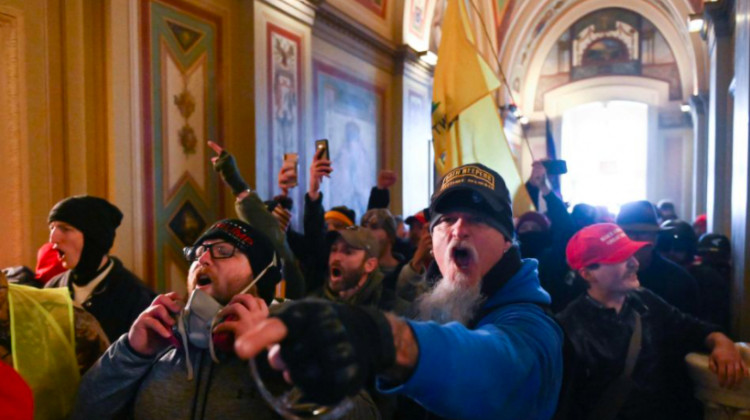 The FBI’s Indianapolis office said Jon Ryan Schaffer (center, pointing) turned himself in Sunday after he was featured on an FBI poster seeking the public's help in identifying rioters. - Provided by the FBI