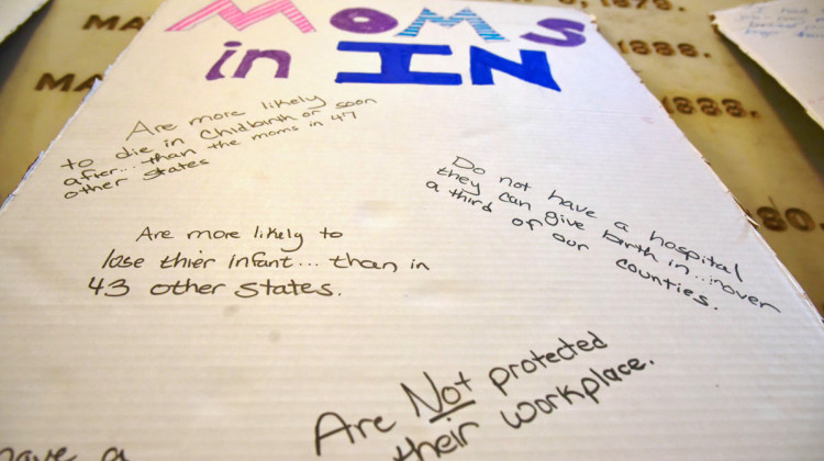 A sign from a rally at the Indiana Statehouse in 2021 says mothers in Indiana aren't protected in workplace and lists other statistics on maternal mortality. - Justin Hicks/IPB News