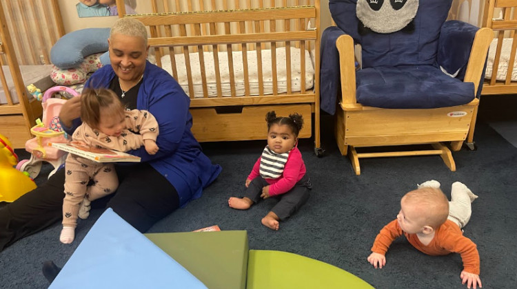 A child care worker reads to three children at Day Early Learning in Indianapolis. The center is recognized as a Level 4 on the Family and Social Service Administration's "Paths to Quality" scale. - Sydney Dauphinais/WFYI