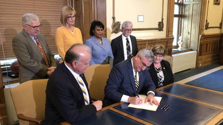 Gov. Eric Holcomb signs legislation to mandate all state lawmakers undergo sexual harassment training each year. - Brandon Smith/IPB News