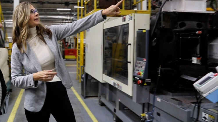 Sherry Dunbar-Kruzan points to an injection molding press at TASUS in Bloomington. As the talent development and recruiting manager, she works with Ivy Tech Community College to set up education and skills training for employees. - Devan Ridgway, WTIU