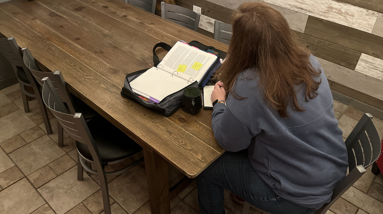 Karla, a parent from northwest Indiana, looks over a report from her daughter’s neuropsychologist. Karla was pressured into signing a non-disclosure agreement, or NDA, by her daughter’s school as part of a special education settlement. - (Lee V. Gaines/WFYI)