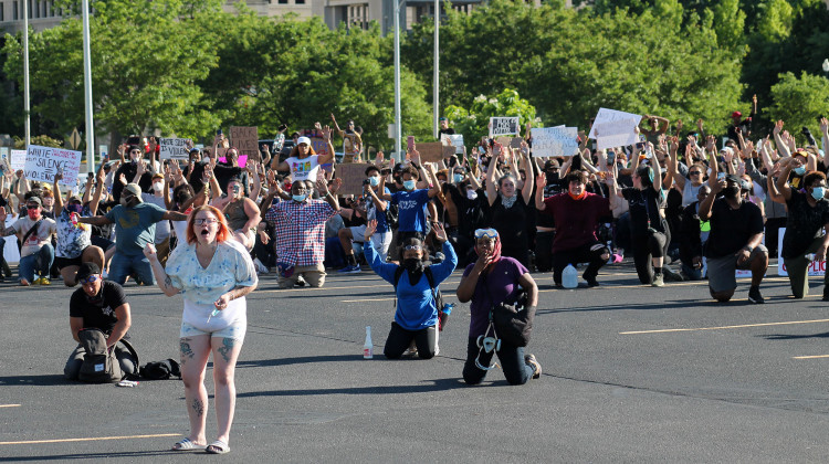 Holcomb Says He's Working On "To-Do List" To Address Racial Injustice - Demonstrators kneel in the parking lot north of the Indiana Statehouse. As protesters regrouped following tear gas deployment, they began calling to others to gather in the parking lot to avoid blocking traffic. (Lauren Chapman/IPB News)