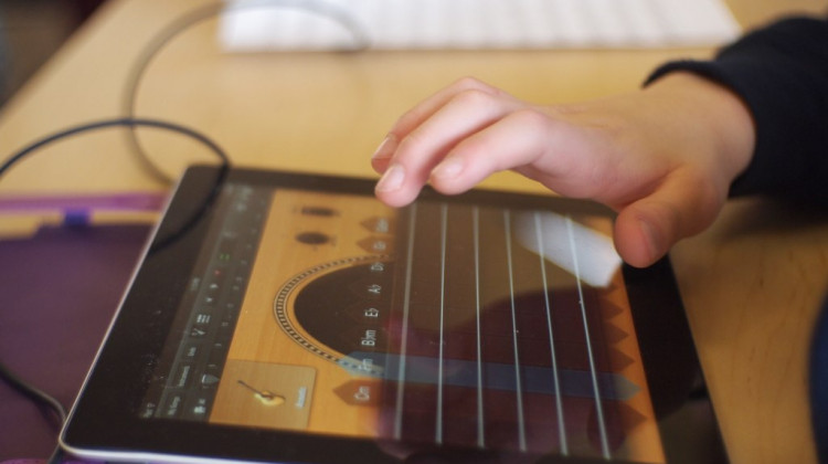 A student touches an iPad with his hand. - Flickr