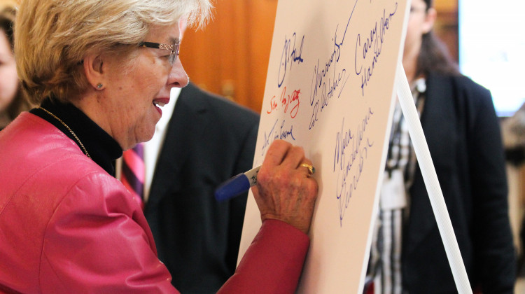 Rep. Sue Errington (D-Muncie) and other lawmakers sign a pledge to support redistricting reform.  - Lauren Chapman/IPB News