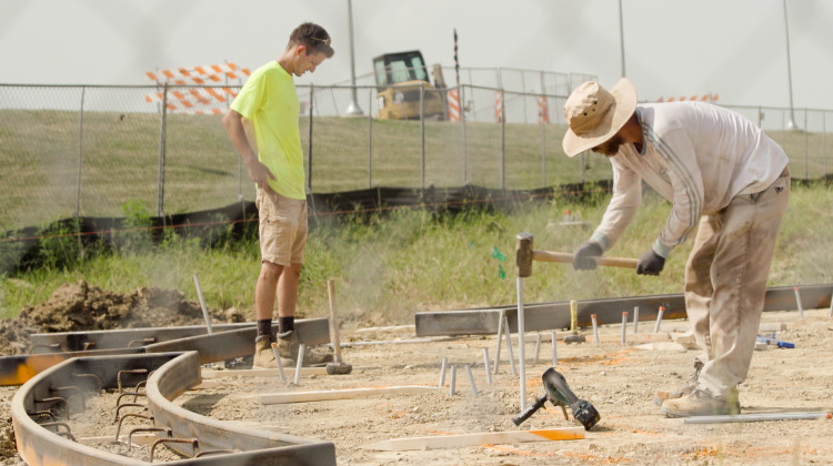 Hunger Skateparks workers Logan Trenum (right)  and Robert Zimmerman, pound stakes on Wednesday afternoon. A small crew is currently building the foundation of  the different park features using dirt and wooden forms.  In a couple weeks, shotcrete will be used to sculpt the park surface itself. - Tim Jagielo / WNIN News  Video Still