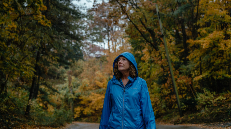 Therese Humphrey Ball walks along the hilly and tree lined streets of her neighborhood in Ogden Dunes, Indiana, on Oct. 25, 2022. Therese walks daily, rain or shine, up to seven miles, and believes exercise is one of the most important ways to keep healthy when dealing with a multiple sclerosis diagnosis. - Jamie Kelter Davis / For Tradeoffs