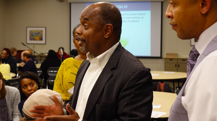 Thom Jackson, CEO of Florida-based Edison Learning, left, talks to Gary community members as Roosevelt principal Joshua Batchelor, right, listens during a public hearing Monday, Dec. 16, 2019. - Eric Weddle/WFYI News