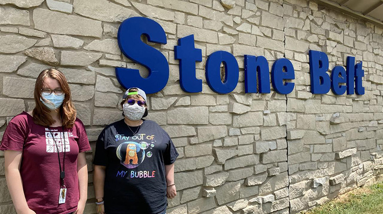 Sage Wright, left, and Mikaela Coppedge, right, stand outside Stone Belt, a nonprofit that supports people with intellectual and developmental disabilities. Coppedge lives and Wright works at Blackstone House, one of Stone Belt's group homes. - Lauren Bavis/Side Effects Public Media