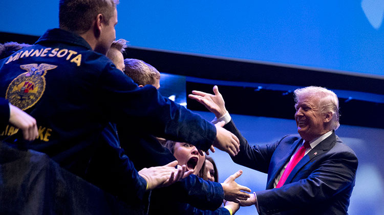 President Donald Trump greets people on stage as he arrives to speak at the 91st Annual Future Farmers of America Convention and Expo at Bankers Life Fieldhouse in Indianapolis, Saturday, Oct. 27, 2018. - AP Photo/Andrew Harnik