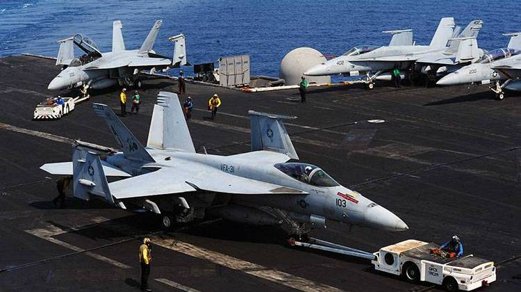 U.S. Sailors move a Navy F/A-18E Super Hornet aircraft assigned to Strike Fighter Squadron (VFA) 31 on the flight deck of the aircraft carrier USS George H.W. Bush (CVN 77) Aug. 26, 2014, in the Persian Gulf as the ship supports operations in Iraq. President Barack Obama authorized humanitarian aid deliveries to Iraq as well as targeted airstrikes to protect U.S. personnel from extremists known as the Islamic State in Iraq and the Levant. - U.S. Navy photo