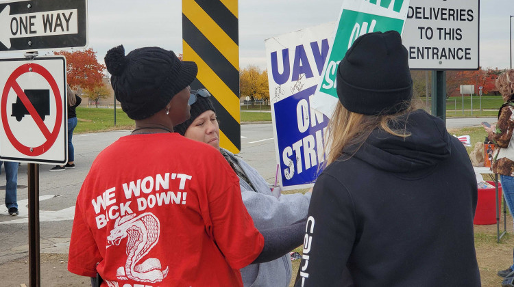 UAW Local 2209 members autograph each others picket signs while cleaning up on the last day of the nationwide strike. - Samantha Horton/IPB News