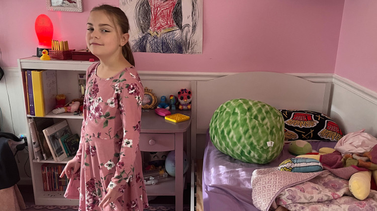 Lena, a fourth grader with multiple chronic health conditions, stands in the bedroom of her northwestern Indiana home on Tuesday, Sept. 26, 2023. Lena’s mom fought the local public school system after administrators said Lena couldn’t attend her neighborhood school and couldn’t bring a private nurse with her to school.  - Dylan Peers McCoy / WFYI