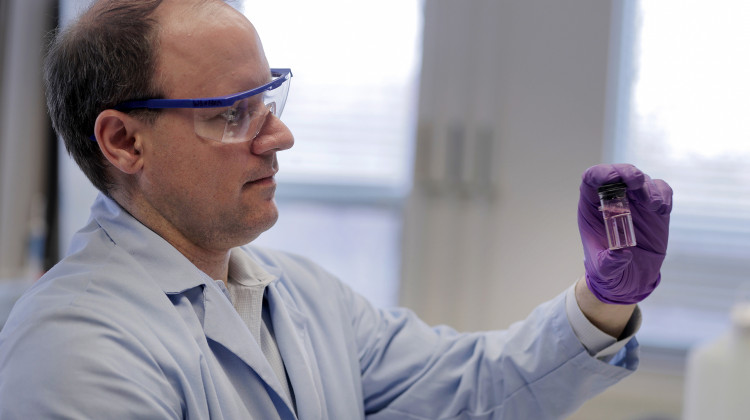 Purdue University professor Andrew Whelton looks at water sample from a faucet. The pink color shows that the sample may contain chlorine — a disinfectant used by utilities to kill bacteria.  - Courtesy of Purdue University