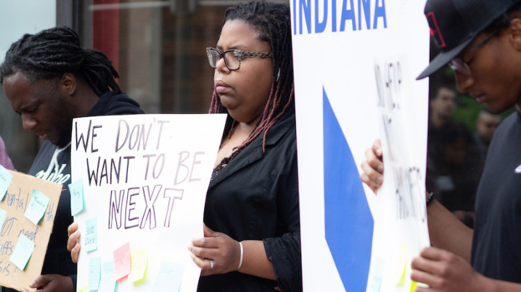 Volunteers with Faith in Indiana hold signs during a vigil for Herman Whitfield III on April 27, 2022, at City Market. Whitfield died April 25 while in police custody. - Tyler Fenwick/Indianapolis Recorder