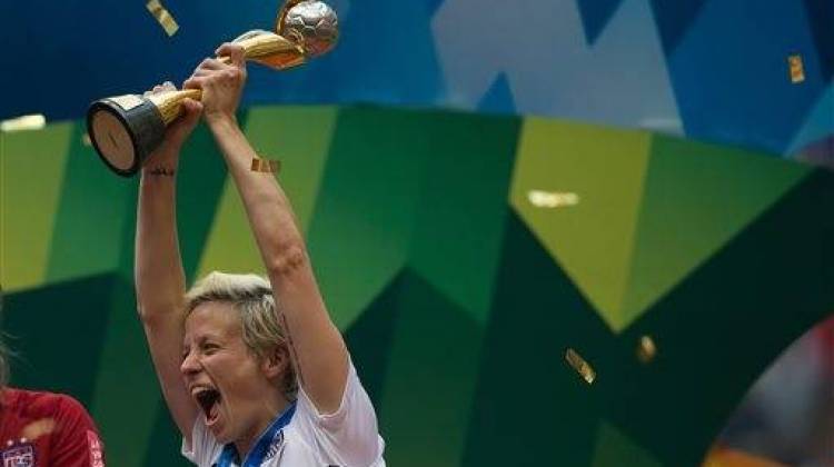 United States' Megan Rapinoe hoists the trophy as she celebrates after defeating Japan to win the FIFA Women's World Cup soccer championship in Vancouver, British Columbia, Canada, Sunday, July 5, 2015. - Darryl Dyck/The Canadian Press via The Associated Press