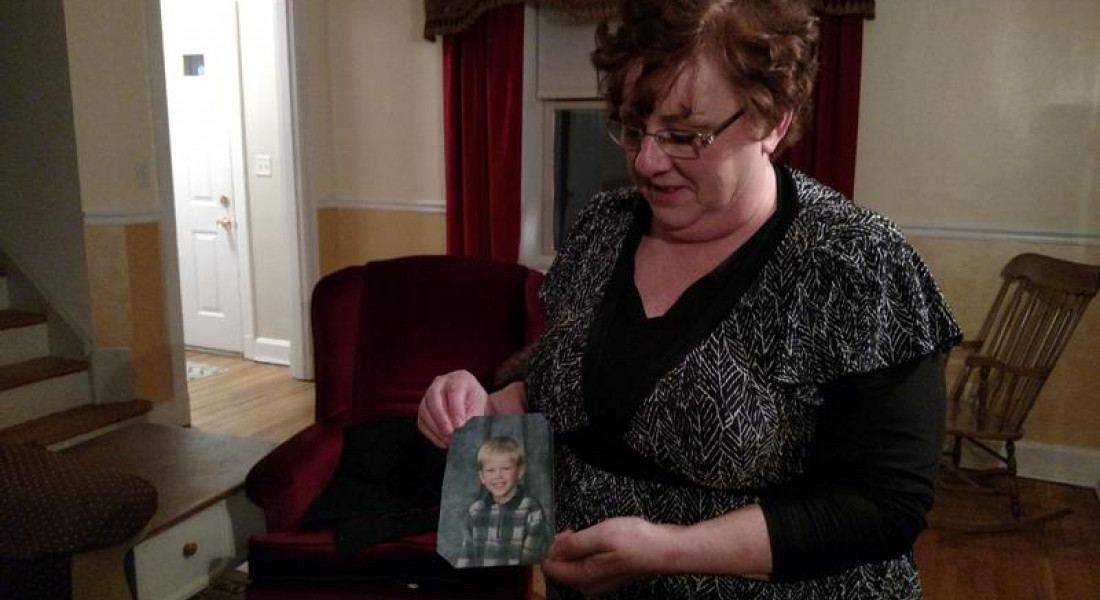 Toni Hoy holds a picture of her son, Daniel, at her home in Rantoul, Illinois. In a last-ditch effort to get Daniel treatment for his severe mental illness, they gave him up to the state in 2008, when he was 12. - Christine Herman/Illinois Public Media