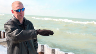 Ogden Dunes resident Rodger Howell says because there's no stone toe protection in front of seawalls along part of the town's shore, waves crash over those walls and wash the sand out behind them. - Alan Mbathi/IPB News